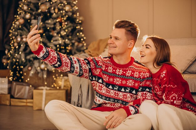 Paar mit Telefon zusammen an Weihnachten