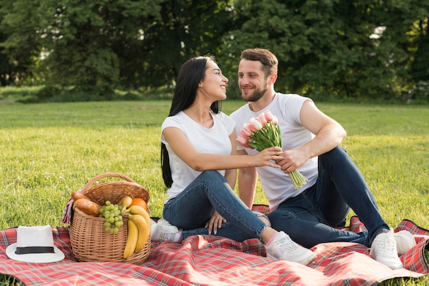 Kostenloses Foto paar posiert auf einer picknickdecke