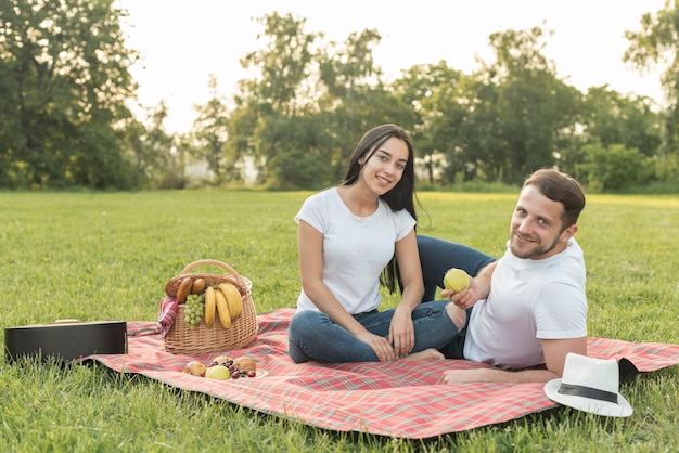 Kostenloses Foto paar posiert auf einer picknickdecke