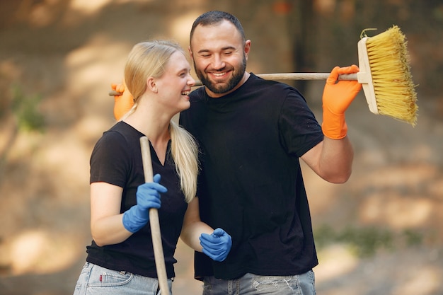 Paar sammelt Blätter und säubert den Park