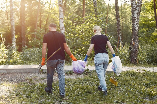 Paar sammelt Müll in Müllsäcken im Park