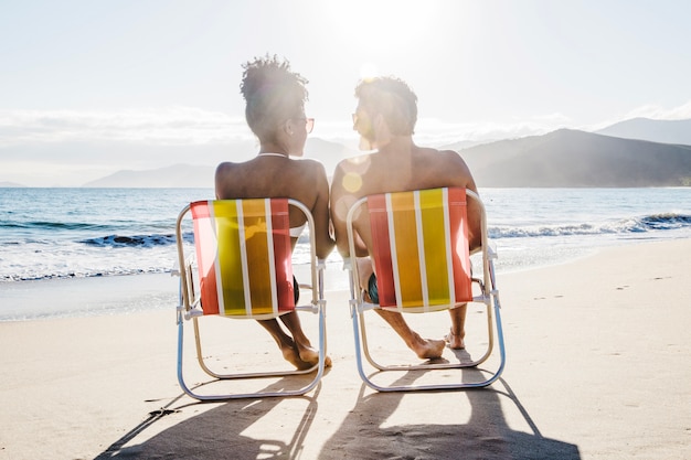 Paar sitzt am Strand mit Sonnenschein