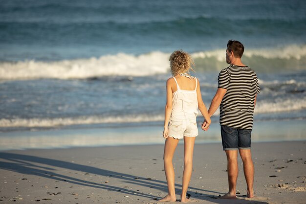 Paar stehen zusammen Hand in Hand am Strand