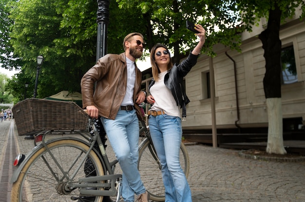 Paar trägt Kunstlederjacken und macht Selfie zusammen im Freien