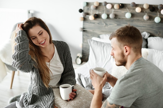 Paar trinkt Morgenkaffee im Schlafzimmer