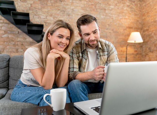 Paar zu Hause mit Videoanruf mit Familie