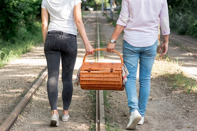 Paare auf einer Eisenbahn, die einen Picknickkorb trägt