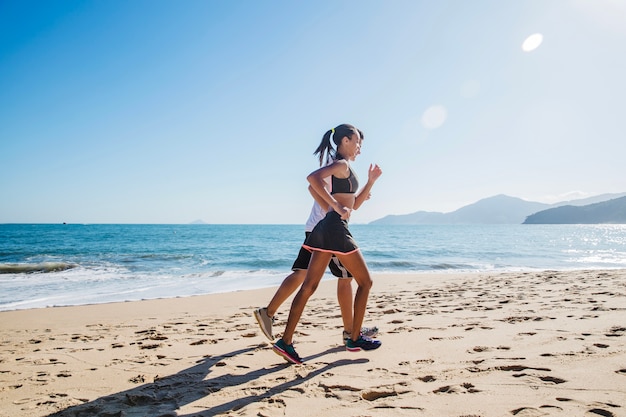 Paare, die am Strand laufen