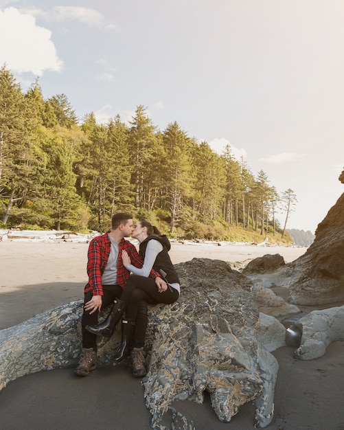 Paare, die auf Felsen am Strand küssen