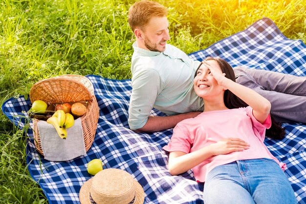 Paare, die auf Picknick liegen und stillstehen