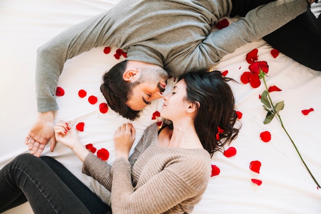 Paare, die auf rosafarbenen Blumenblättern schlafen