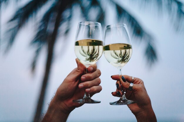 Paare, die ein Glas Wein am Strand genießen