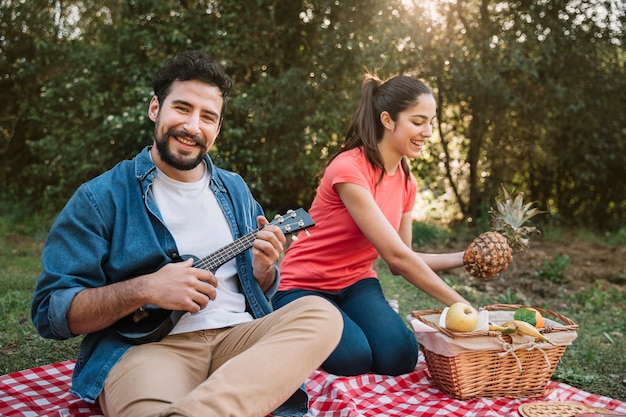 Kostenloses Foto paare, die ein picknick mit gitarre haben