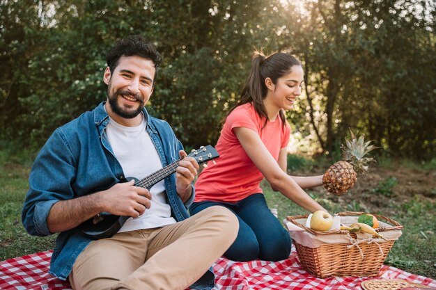 Paare, die ein Picknick mit Gitarre haben