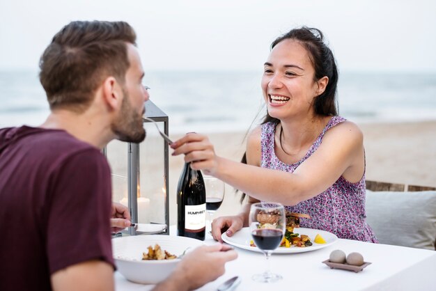 Paare, die ein romantisches Abendessen am Strand genießen