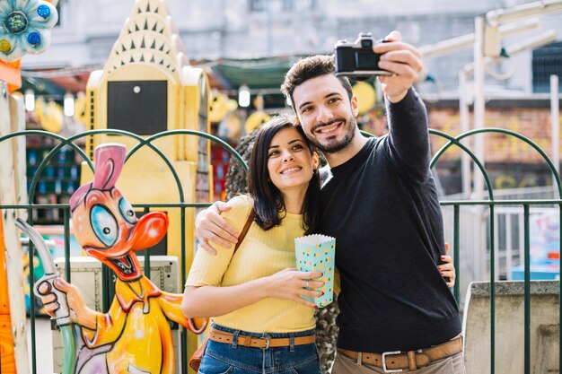 Paare, die ein selfie in einem Freizeitpark nehmen