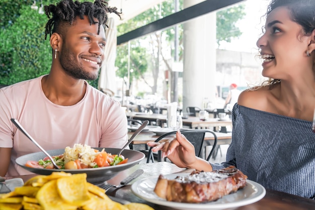 Paare, die eine gute Zeit zusammen genießen und verbringen, während sie ein Date in einem Restaurant haben.