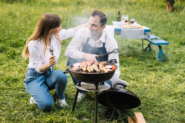 Paare, die einen Grill in der Natur tun