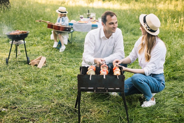 Paare, die einen Grill in der Natur tun