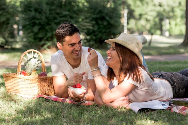 Paare, die Erdbeeren am Picknick essen