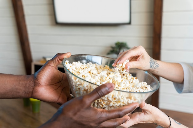 Paare, die etwas Popcorn trinken, während sie einen Film sehen