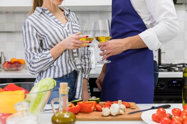 Paare, die Gläser Wein in der Küche klopfen