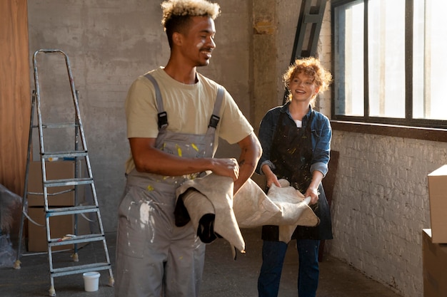 Kostenloses Foto paare, die in ihrem neuen zuhause gemeinsam einen teppich handhaben