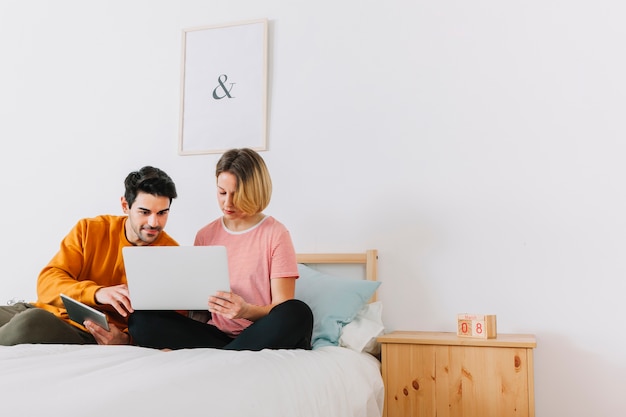 Paare, die Laptop im Schlafzimmer verwenden