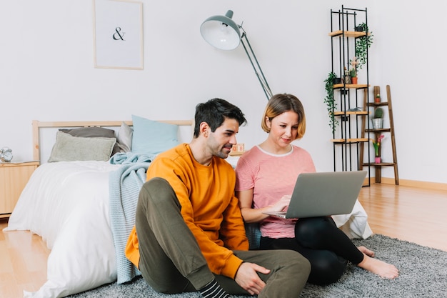 Paare, die Laptop im Schlafzimmer verwenden