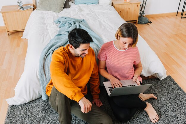 Paare, die Laptop nahe Bett verwenden