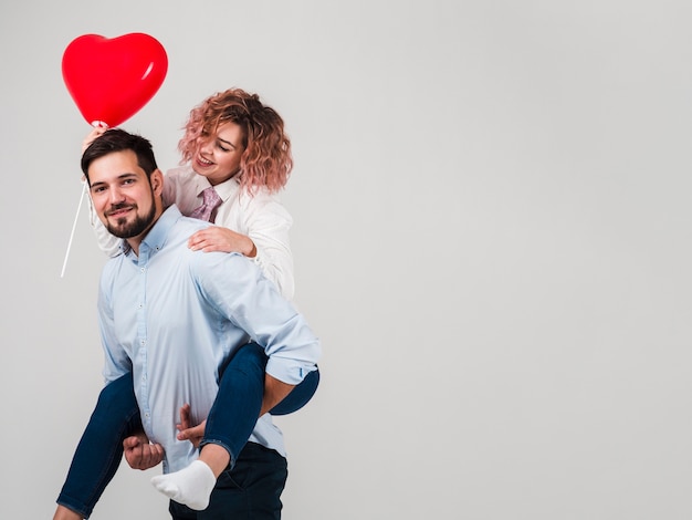 Paare, die mit Ballon für Valentinsgrüße aufwerfen