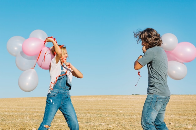 Paare, die mit Ballonen kämpfen