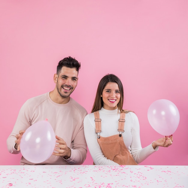 Kostenloses Foto paare, die mit weißen ballonen auf händen stehen