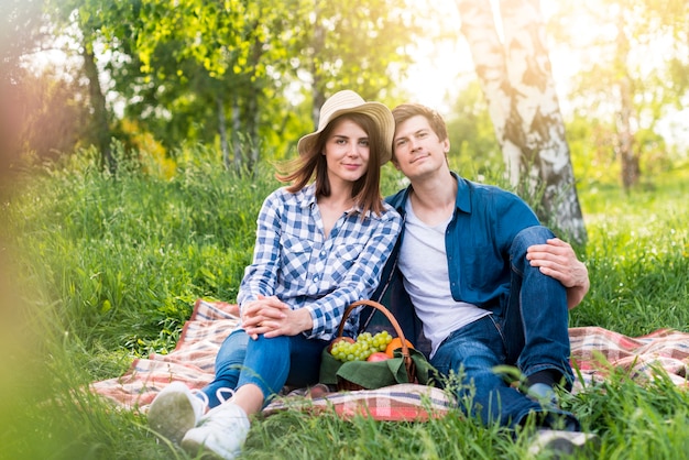 Paare, die reizendes Picknick auf Lichtung haben