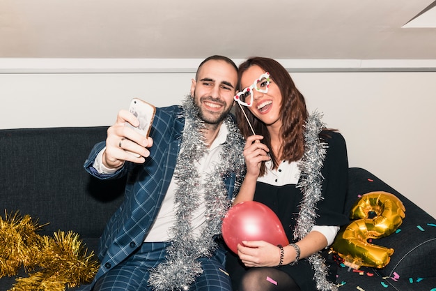 Paare, die selfie auf Couch nehmen