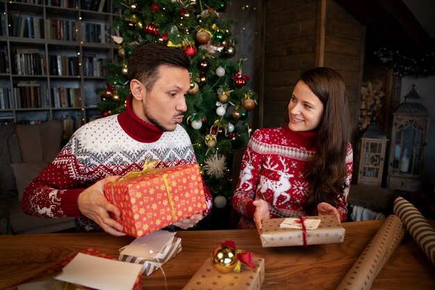 Paare, die sich Weihnachtsgeschenke machen