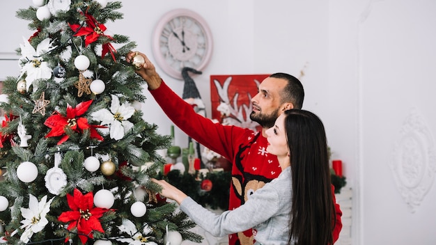 Paare, die Weihnachtsbaum schmücken