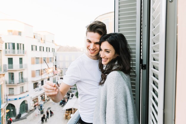 Paare, die Wunderkerzen auf Balkon betrachten