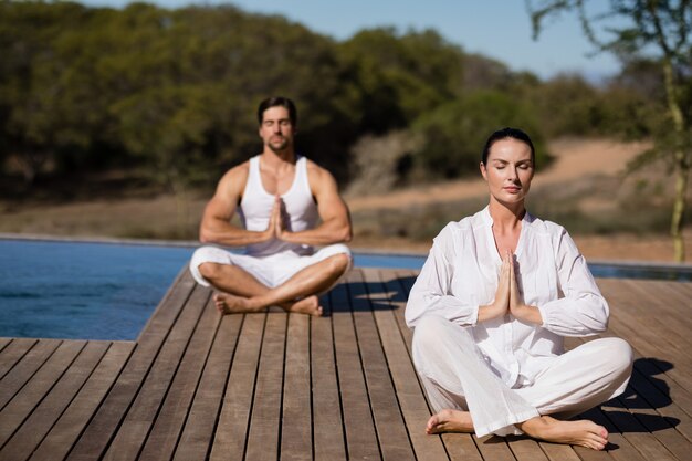 Paare, die Yoga an den Safariferien durchführen