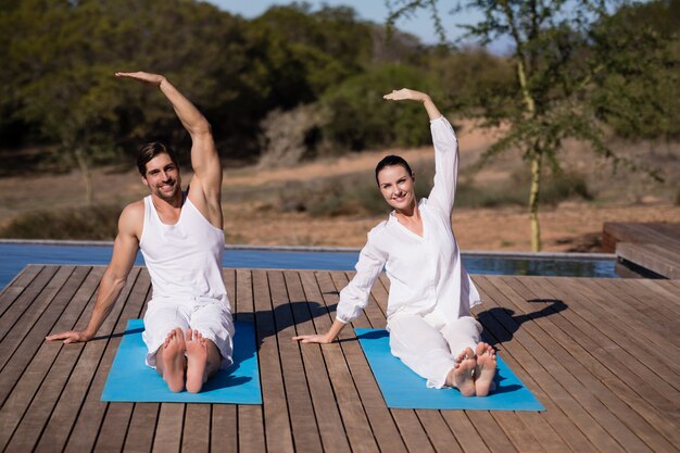 Paare, die Yoga an den Safariferien durchführen