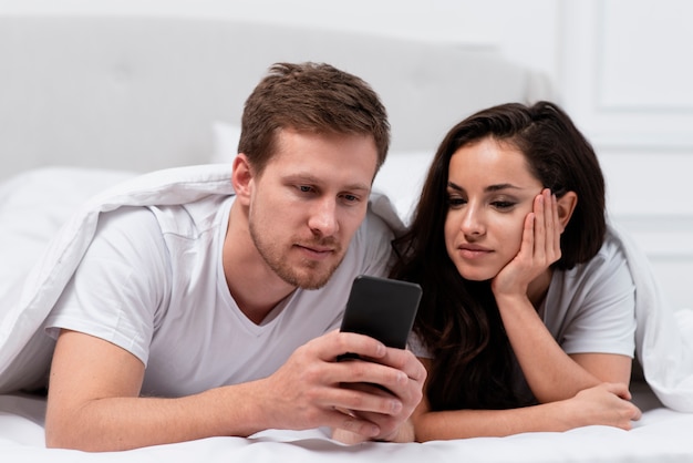 Paare, die zum Social Media im Bett gewöhnt werden