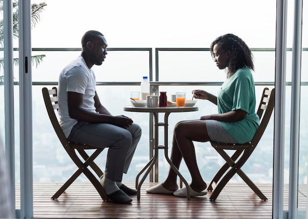 Paare, die zusammen am Balkon frühstücken