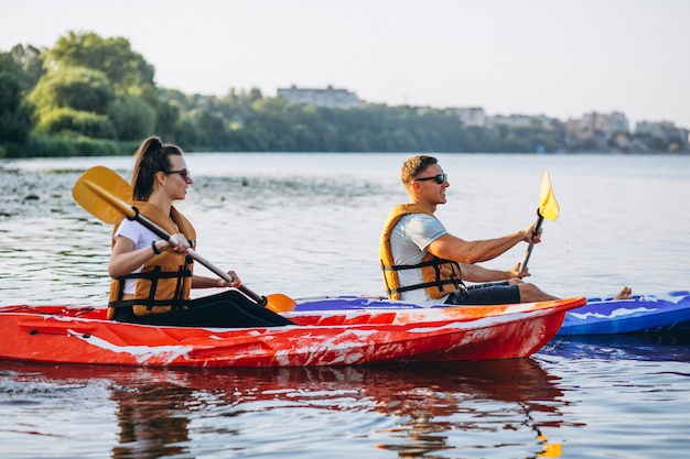 Paare, die zusammen auf dem Fluss Kayak fahren