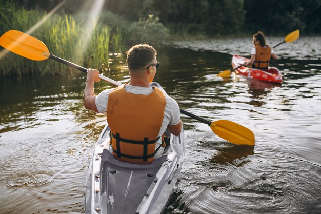 Paare, die zusammen auf dem Fluss Kayak fahren