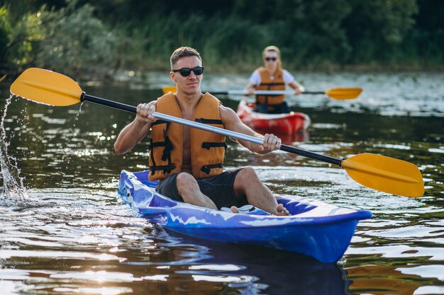 Paare, die zusammen auf dem Fluss Kayak fahren