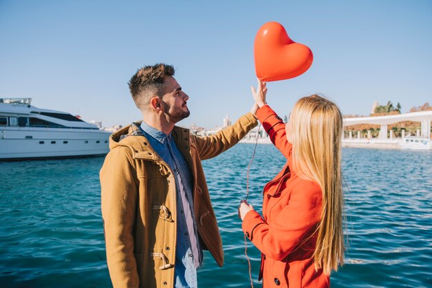 Paare in der Liebe mit rotem Ballon