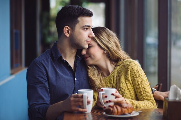 Paare in trinkendem Kaffee der Liebe in der Kaffeestube