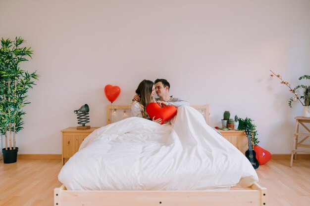Paare mit Herzen im stilvollen Schlafzimmer