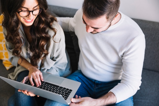 Paare mit Laptop auf Sofa zu Hause