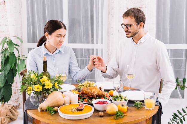 Kostenloses Foto paarhändchenhalten am festlichen tisch